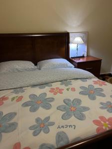 a bed with a blanket with flowers on it at Comfortable room in Riverside in Riverside