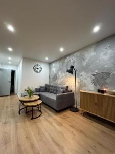 a living room with a couch and a table at Apartament Klonova na Mazurach in Olecko