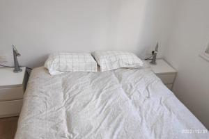 ein weißes Bett mit zwei Kissen darüber in der Unterkunft Precioso apartamento con magnífico patio. in Sant Feliu de Llobregat