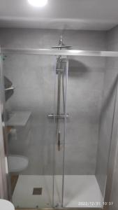 ducha con puerta de cristal y lavamanos en Precioso apartamento con magnífico patio. en Sant Feliu de Llobregat