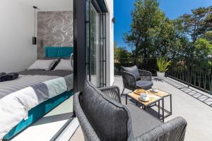 ein Schlafzimmer mit Bett und Stühlen auf einem Balkon in der Unterkunft Vila Petram in Bribir