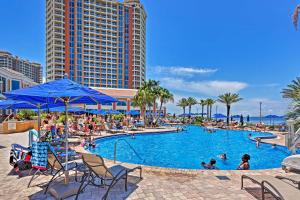 una piscina en un complejo con gente dentro en Florida Resort Condo Walk to Pensacola Beach!, en Gulf Breeze