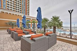 un patio con sillas y sombrillas y una piscina en Florida Resort Condo Walk to Pensacola Beach!, en Gulf Breeze