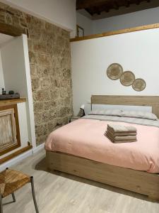 a bedroom with a bed and a stone wall at La Casina del Corso in Massa Marittima +68 photos