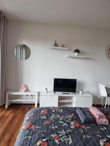 a bedroom with a bed and a tv on a white wall at Ferienwohnung Köln in Cologne