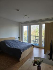 a bedroom with a bed and a view of a balcony at Ferienwohnung Köln in Cologne