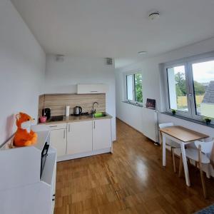 a kitchen with white cabinets and a wooden table at Ferienwohnung Köln in Cologne