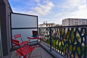 un balcón con 2 sillas y un ordenador portátil. en Écho Parisien, en Aubervilliers