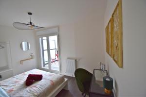 Un dormitorio con una cama y una mesa y una ventana. en Écho Parisien, en Aubervilliers