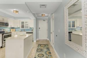 a kitchen with white cabinets and a white door at Beach Villas # 304 - BOGO24 condo in Fort Myers Beach