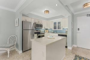 a kitchen with a stainless steel refrigerator and a chair at Beach Villas # 304 - BOGO24 condo in Fort Myers Beach
