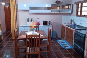 cocina con mesa y mesa de madera con sillas en Casa de Praia em Xangri-lá a 3 quadras do mar en Xangri-lá