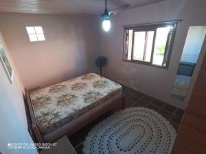 Habitación pequeña con cama y ventana en Casa de Praia em Xangri-lá a 3 quadras do mar en Xangri-lá