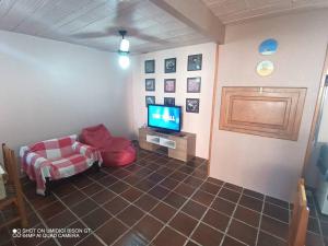 sala de estar con sofá y TV en Casa de Praia em Xangri-lá a 3 quadras do mar en Xangri-lá