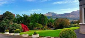 uma vista para um jardim com montanhas ao fundo em Enniskeen Country House Hotel em Newcastle