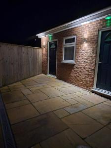 a patio in front of a brick building at night at The Woodmans Cottage 