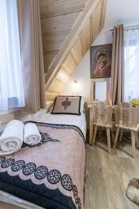 een slaapkamer met een bed in een kamer met houten plafonds bij Pokoje i Apartamenty Olivia in Zakopane