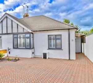 a white house with a brick driveway at Betty's Bungalow in Lancing