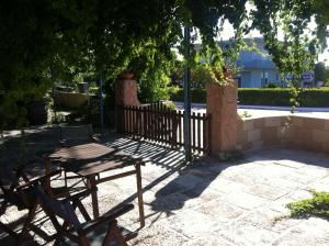 a wooden table and chair in front of a fence at Maistrali Hotel & Restaurant in Kalavárda