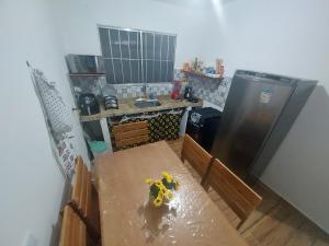 - Vistas a una cocina con mesa y nevera en Lugar tranquilo e aconchegante, en Tibau do Sul