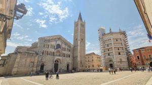 un gran edificio con una torre de reloj en una ciudad en Luxury 3 al duomo di parma en Parma