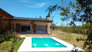 a villa with a swimming pool in front of a house at Los Moros Country in San Rafael