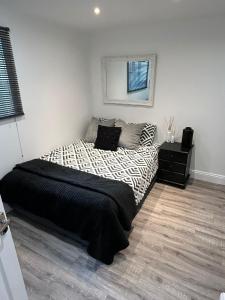 a bedroom with a bed with a black and white comforter at Hertford HOME in Hertford