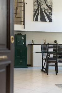 Cette chambre comprend un poêle vert, une table et des chaises. dans l'établissement La Casa del Forziere Verde, à La Spezia