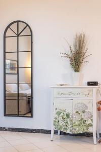 ラ・スペツィアにあるLa Casa del Forziere Verdeの鏡と植物を乗せたドレッサー