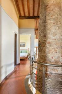a room with a stone pillar and a bedroom at Cozy room at Podere Noceto in Grotti