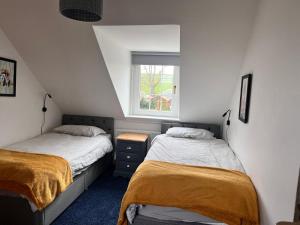 two beds in a small room with a window at 2 Swinton Mill Farm Cottage in Swinton