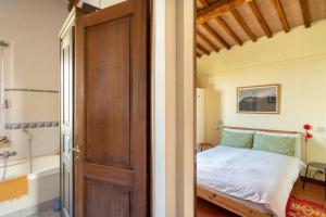 a bedroom with a bed and a bathroom with a tub at Cozy room at Podere Noceto in Grotti