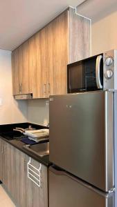 a kitchen with a stainless steel refrigerator and a microwave at Smdc Breeze Residences in Manila