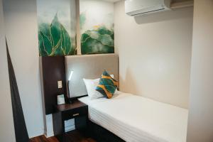 a bedroom with a bed with a pillow on it at Auckland City Hotel - Hobson St in Auckland