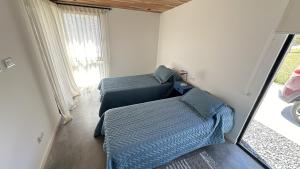 a bedroom with a bed and a couch and a window at Casa Pit - Casa en chapa con pileta Barrio Privado 6PX I Hola Sur in Mar del Plata