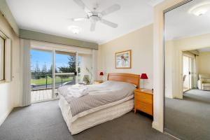ein Schlafzimmer mit einem Bett und einem großen Fenster in der Unterkunft Harbourwatch 11 18 Burrawan Street in Port Macquarie
