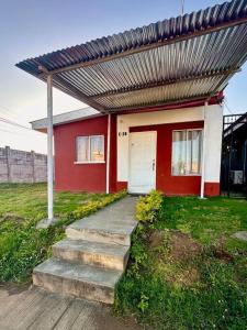 una casa roja y blanca con techo metálico en Hidden Gem en Managua