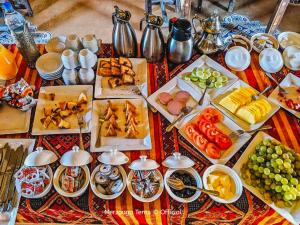 une table avec de nombreuses assiettes de nourriture dans l'établissement Merzouga Tents © Official, à Merzouga