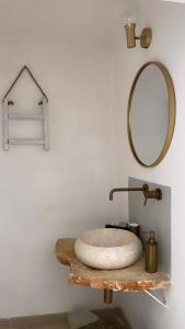 a bathroom with a stone sink and a mirror at Arquati Suite Luxury Apartment in Ostuni