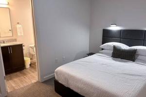 a bedroom with a large bed and a bathroom at The Best of Downtown Living in Baton Rouge