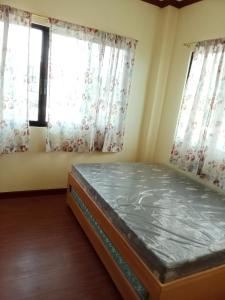 a bedroom with a bed in front of two windows at Villa Ceferina in Tagbilaran City
