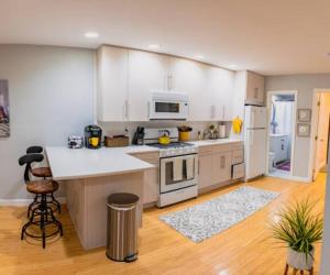 een keuken met witte kasten en een witte koelkast bij New Beautiful Condo In Bayonne near NYC. in Bayonne