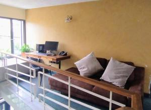 波哥大的住宿－Innovar Casa Hostal，客厅配有沙发和带电脑的书桌