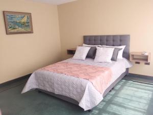 a bedroom with a large bed with a pink blanket at Innovar Casa Hostal in Bogotá