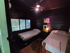 a bedroom with two beds and a ceiling fan at Casa Aris in Escuintla