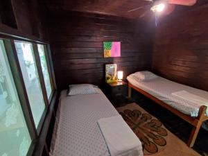 Cette petite chambre comprend 2 lits et une fenêtre. dans l'établissement Casa Aris, à Escuintla