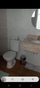 y baño con aseo y lavamanos. en Espaço Cris, en Pindamonhangaba