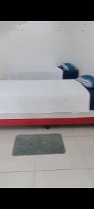 Cama blanca con marco rojo sobre una mesa en Espaço Cris, en Pindamonhangaba