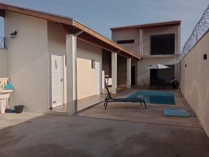 un patio de una casa con piscina y sombrilla en Espaço Cris, en Pindamonhangaba