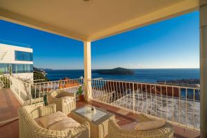 Un balcón con sillas, una mesa y el océano en Isaura Apartments, en Dubrovnik